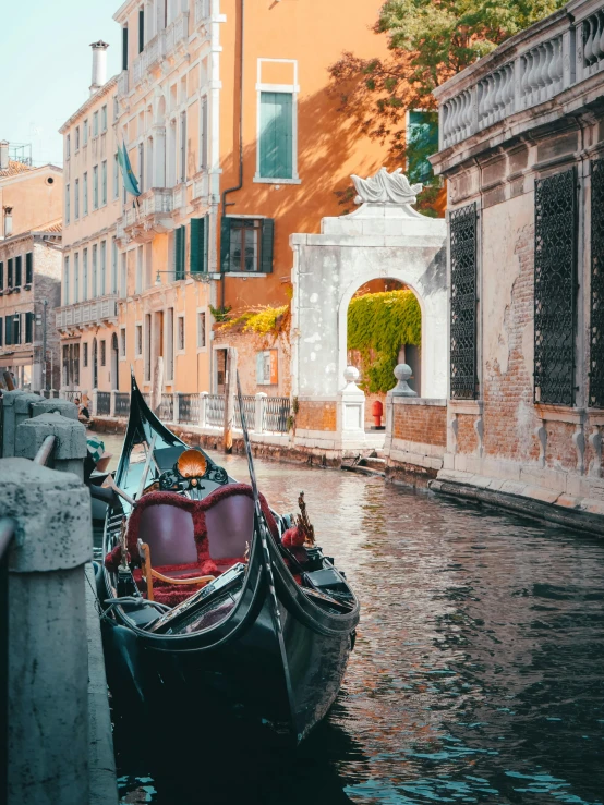 two boats sit in a canal near a building