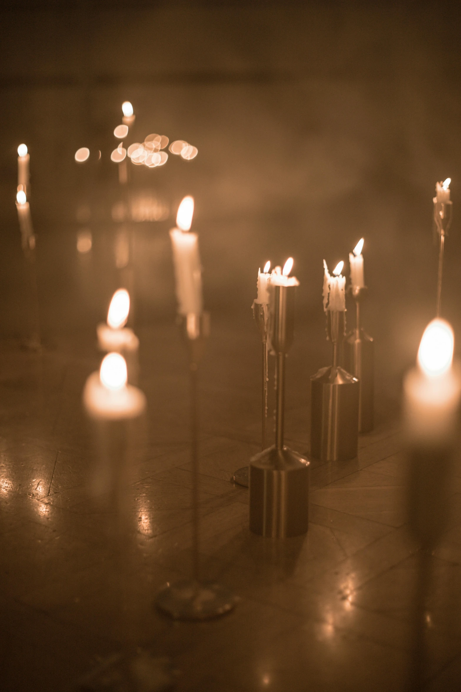 some candles sit on the ground in front of lights