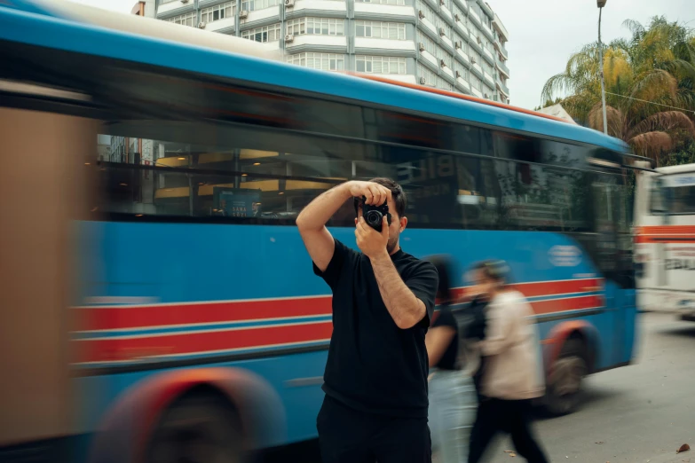 two people walking down the street by a bus