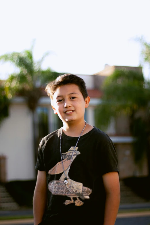 a boy wearing a black shirt and a necklace