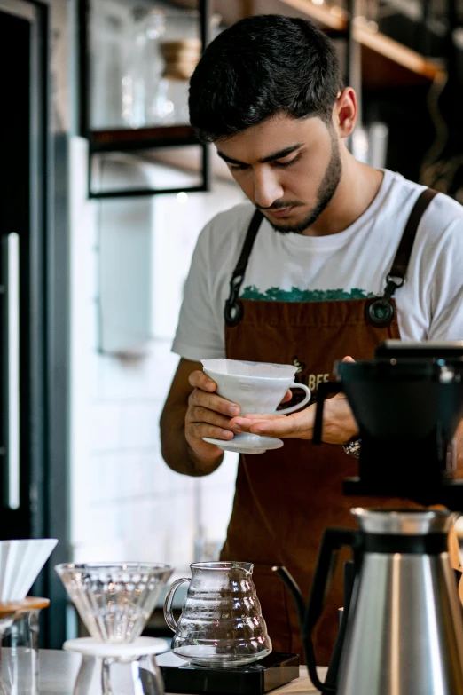 a man pouring coffee in a cup to a small plate