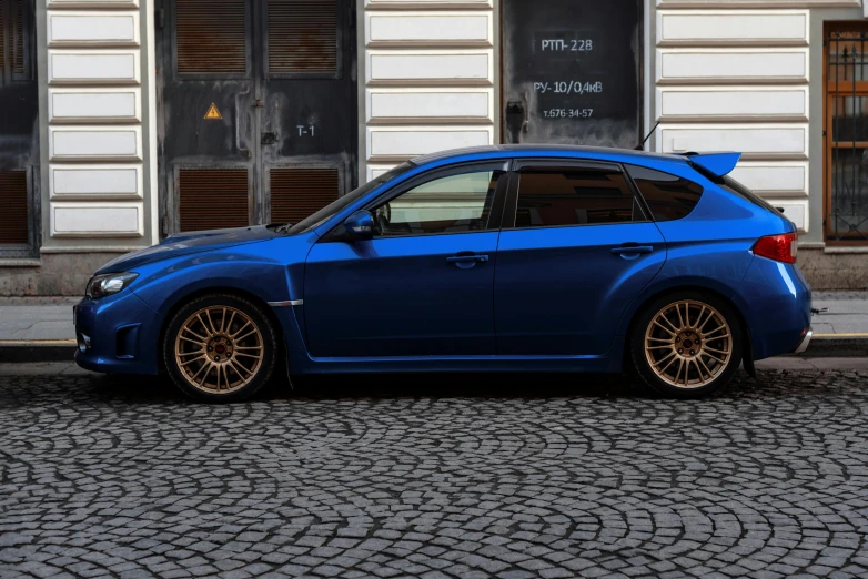 a blue car parked on the street next to a building