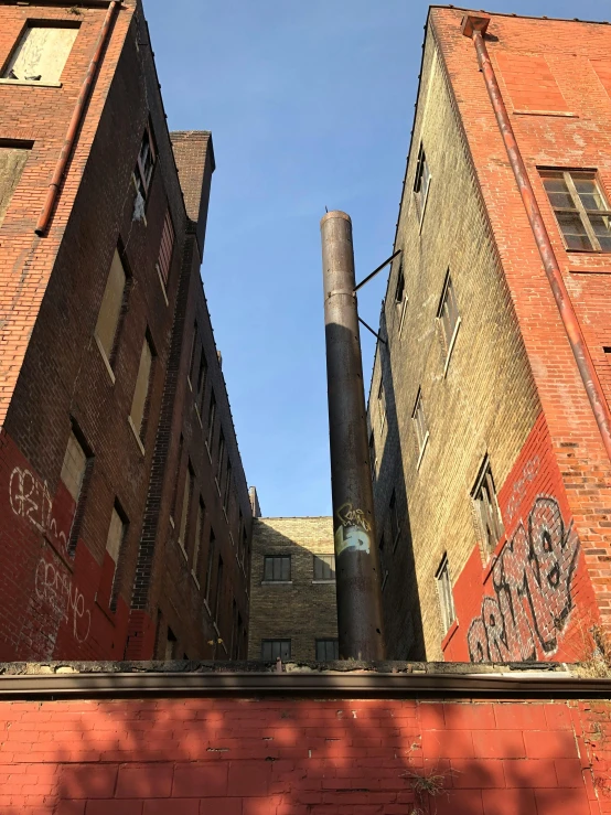 a brick structure with a big black pipe sticking out of it