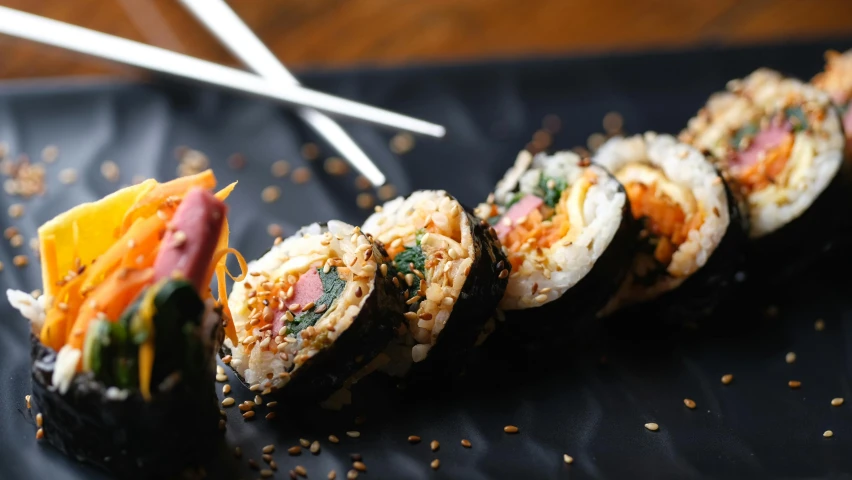 an image of some sushi on a black mat