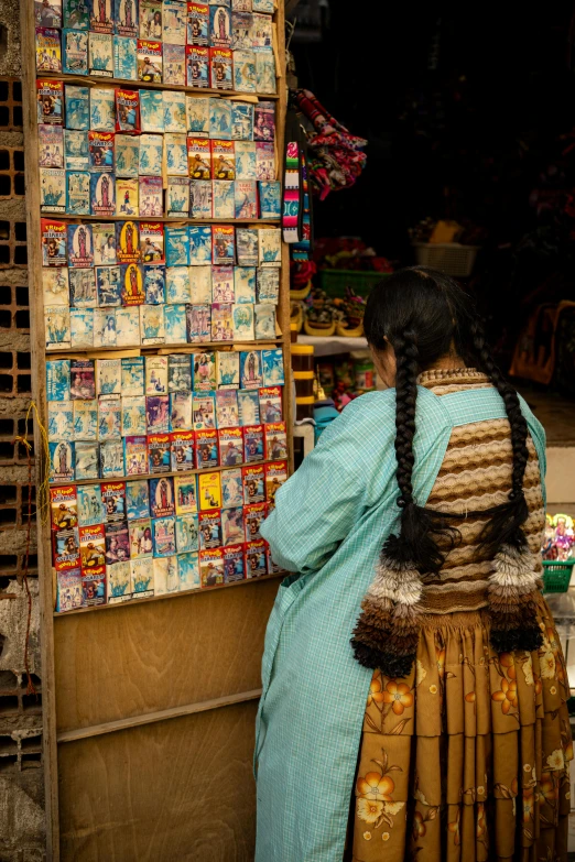 a woman stands in front of a large wall of cereal