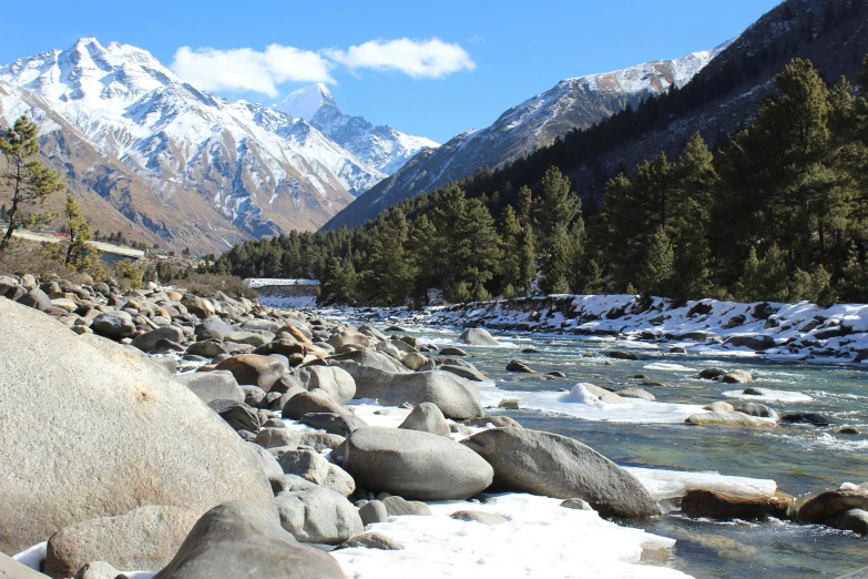 there is snow on the rocks and water in this stream