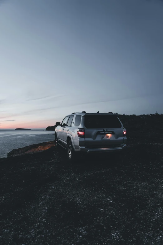 a suv parked next to a body of water