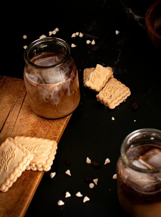 a jar of peanut er and two cut out cookies sitting on a  board