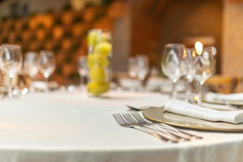 the table is set with silverware and yellow flowers