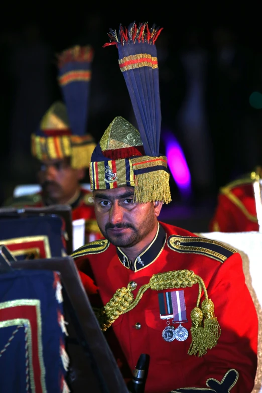 a royal guard in uniform sits on stage