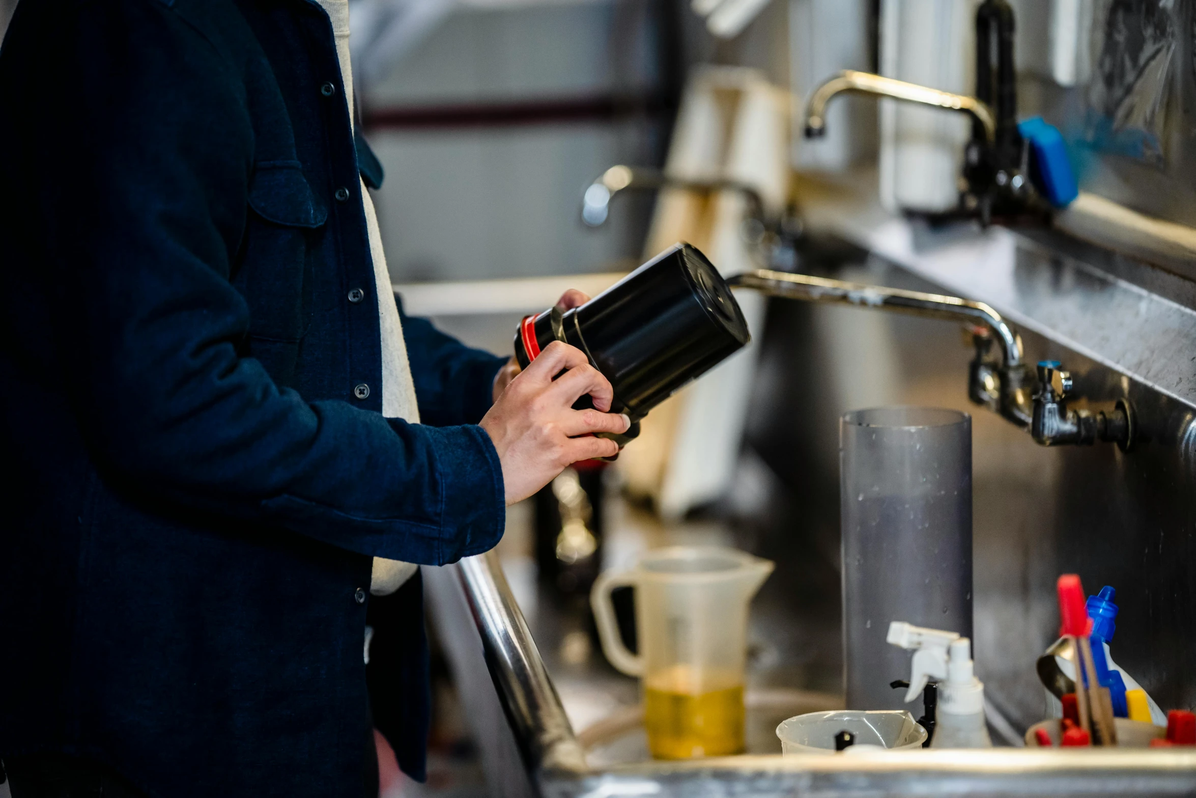 man holding coffee mug in front of the kitchen sink