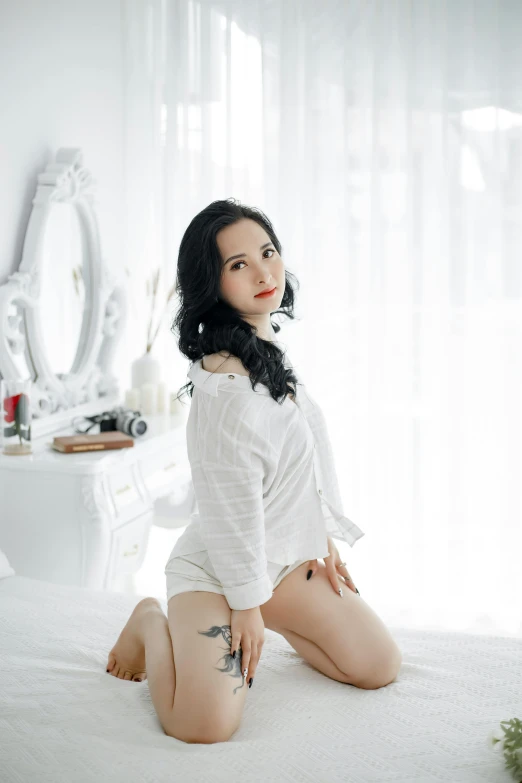 woman with black hair sitting on a bed