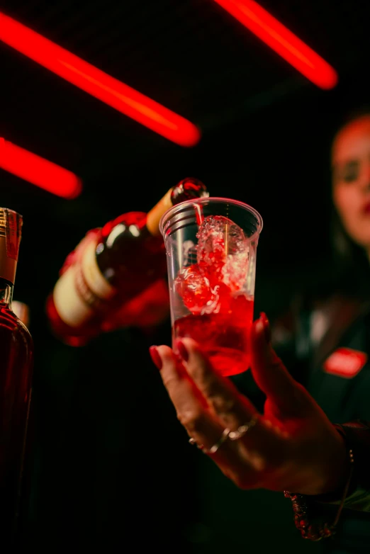 an image of a woman pouring alcohol in a cocktail