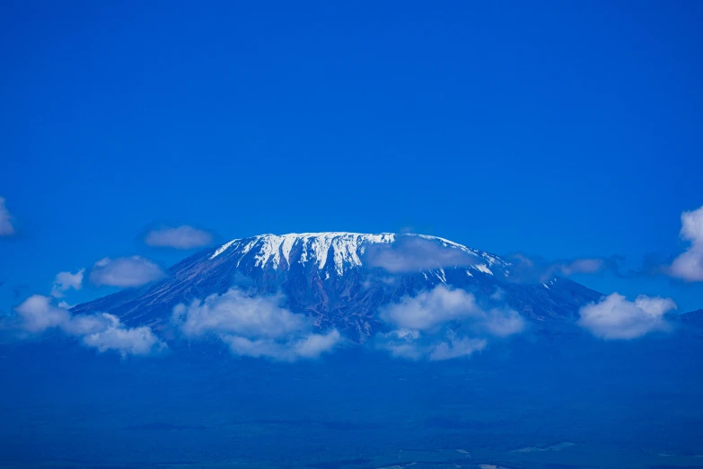 a mountain surrounded by clouds on the top of it