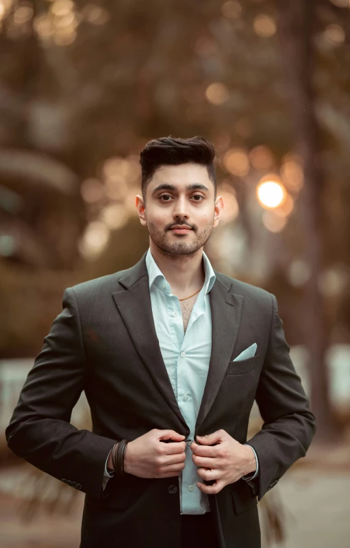 a man in a suit standing next to trees