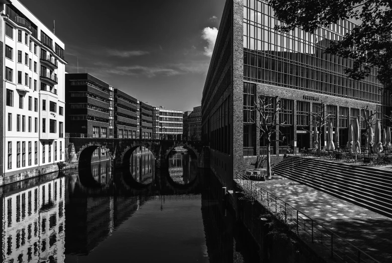 black and white pograph of buildings reflecting in water