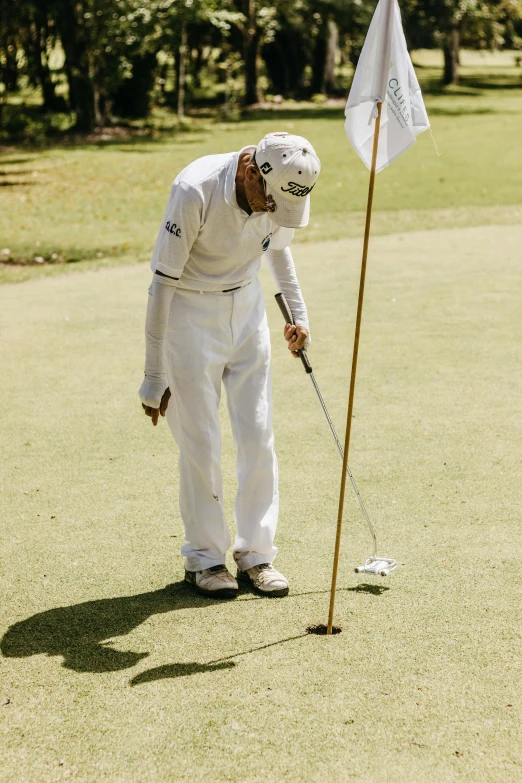 a man on the field holding onto a golf ball