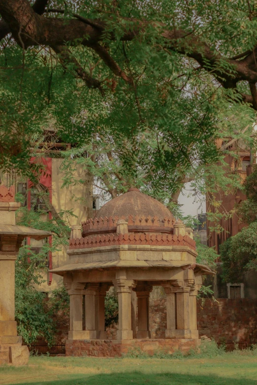 a small stone shrine sitting under a large tree