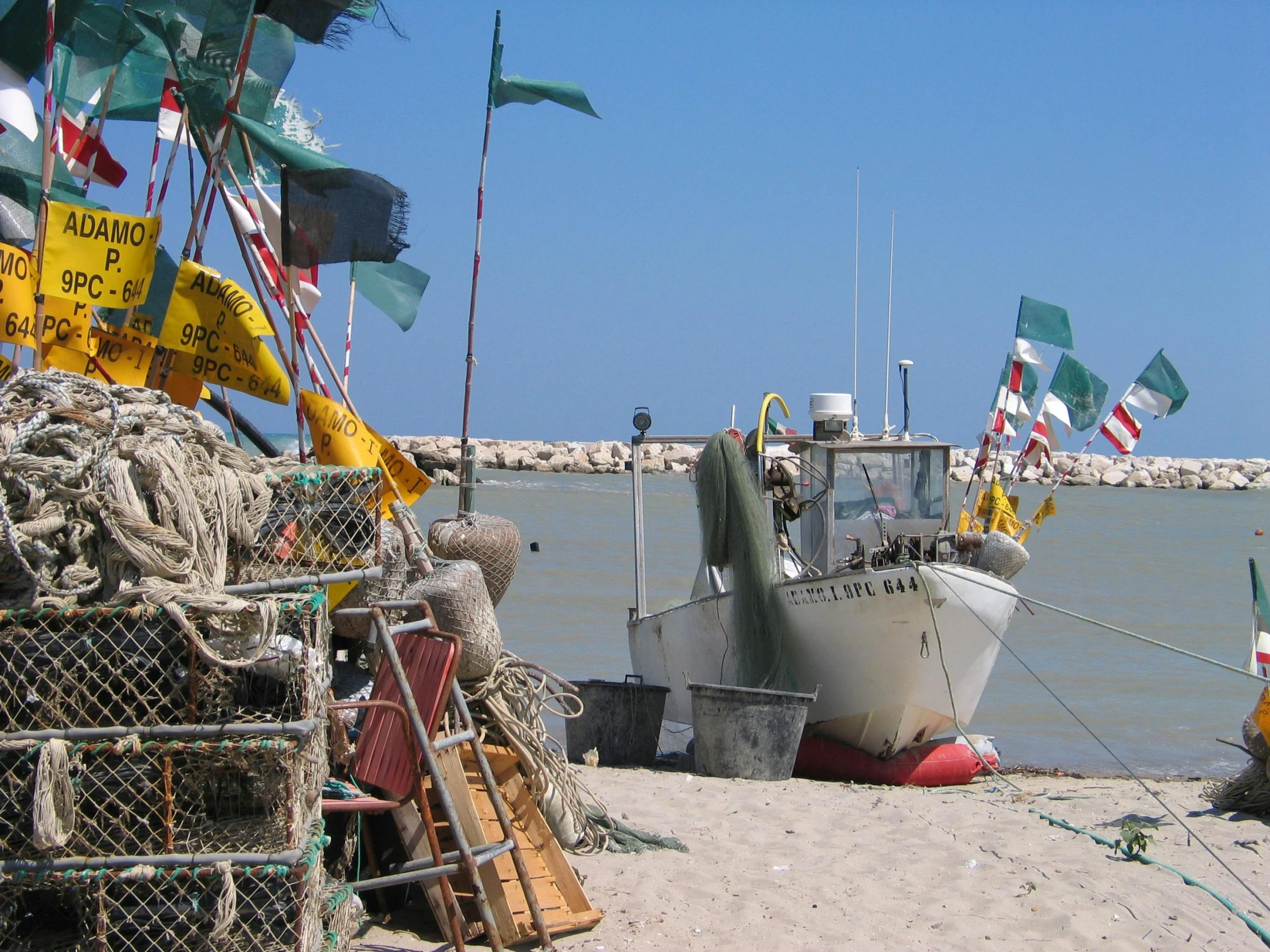 there is a boat on the sand next to the water