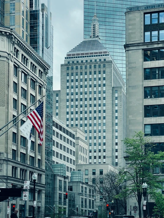 an american flag on a pole at the end of a city street