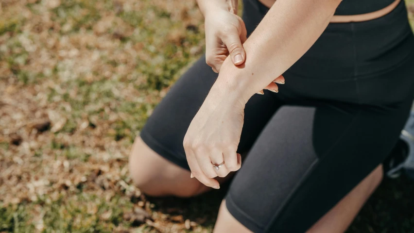 the knee of a female sitting on a grassy field