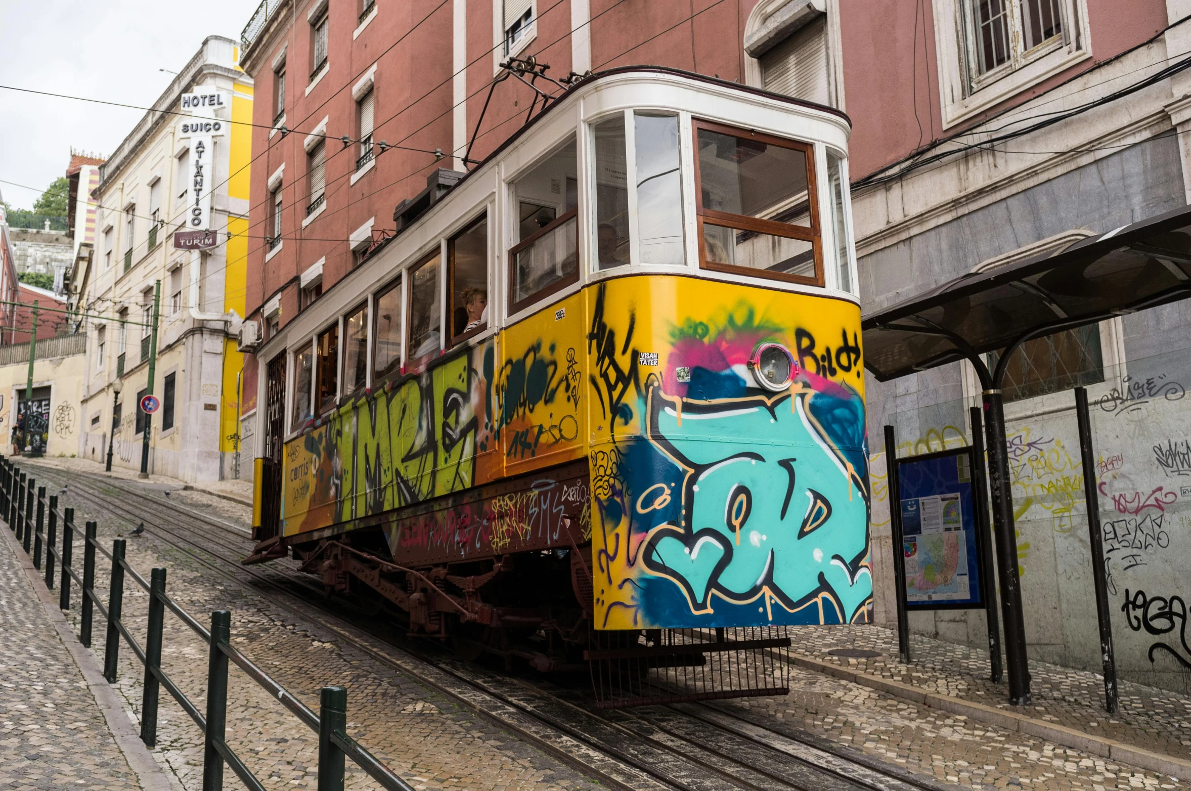 an orange, blue, yellow and green train with graffiti on it