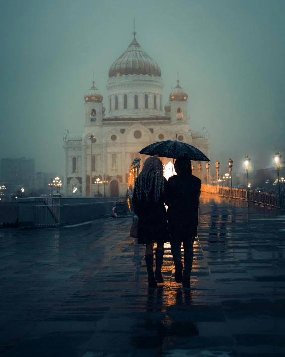 a couple in silhouette stand under an umbrella near the cathedral of st petersburg