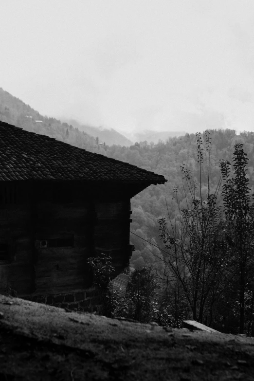 an old log cabin sitting on a hillside