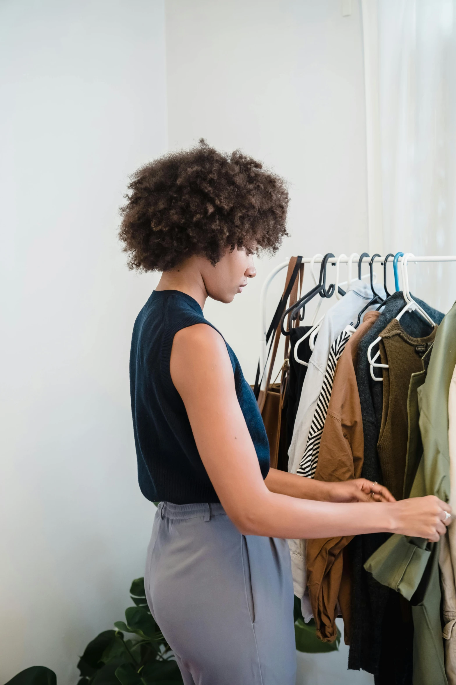 a woman is looking at clothes hanging on a rack