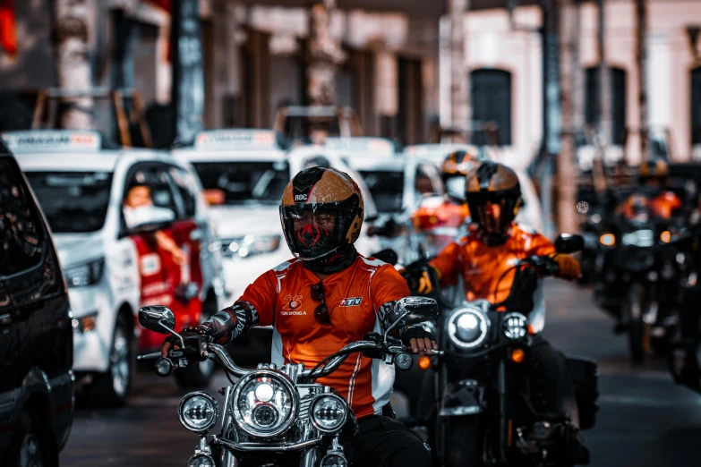 a line of motorcyclists riding down the street