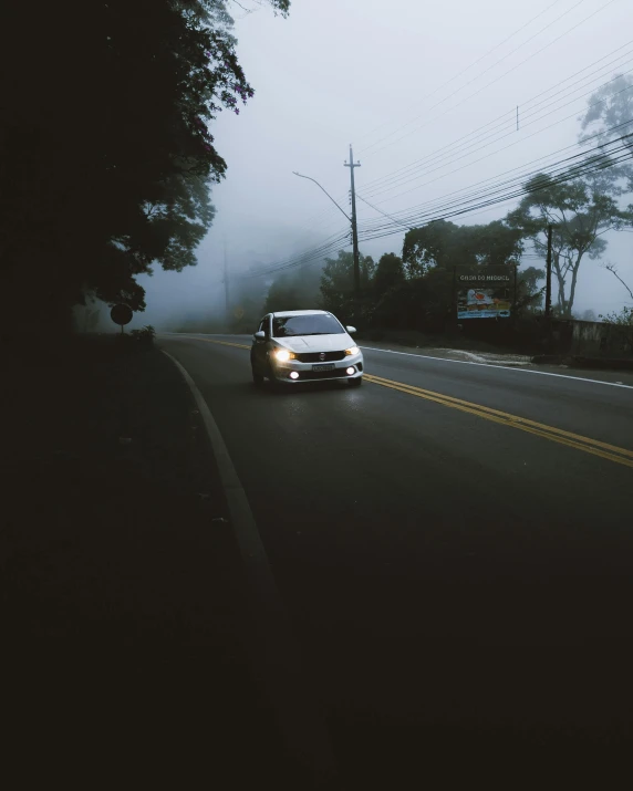 a car drives in a foggy road with an oncoming camera