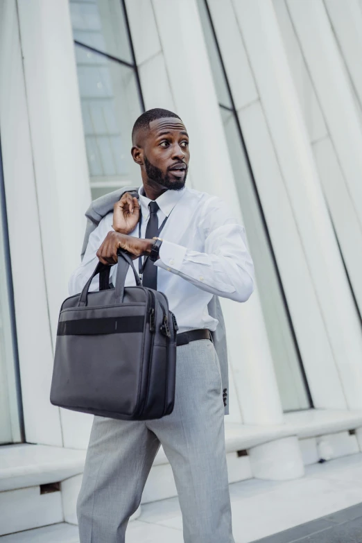 a black man holding a bag and looking away from the camera