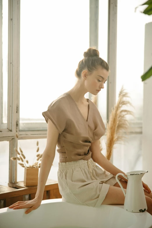 a woman is sitting in a bath tub with her legs on a counter