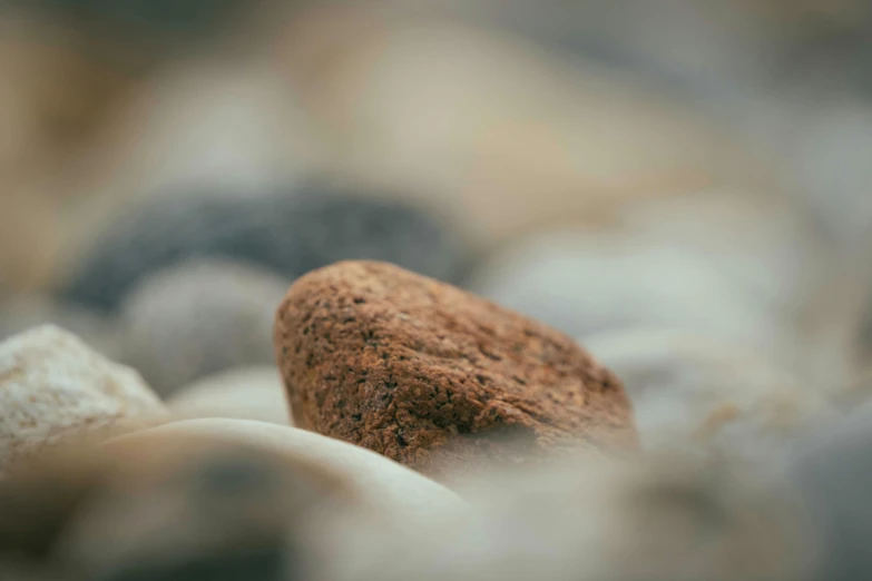 a brown rock sitting on top of some rocks