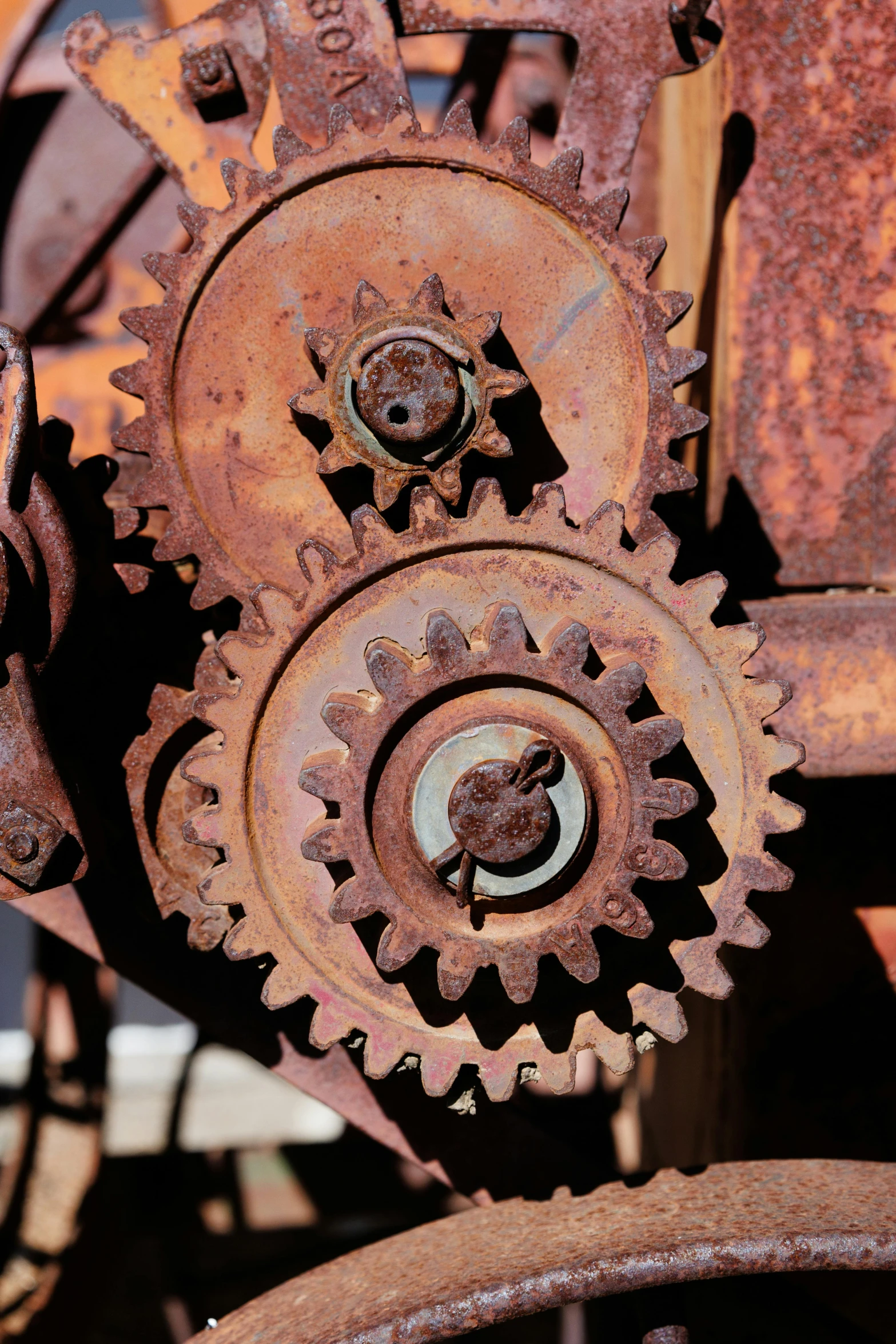 rusted gear is shown in the background with other rusted machinery