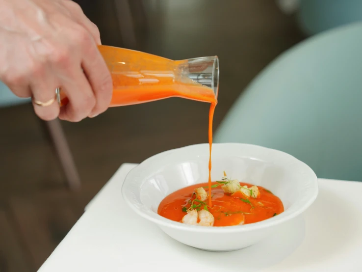 a bowl full of tomato sauce being drizzled on it