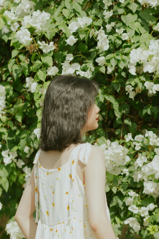 a close up of a woman in front of flowers