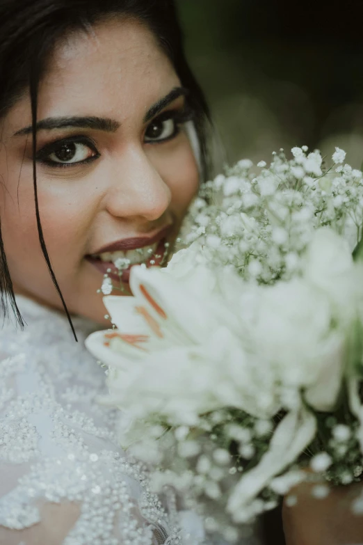 the bride smiles with her bouquet of flowers in her hand