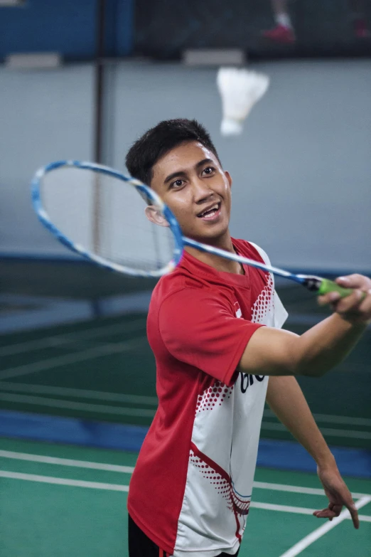 a young man holding a tennis racquet on top of a court