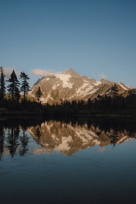 the view of mountains are reflected in water