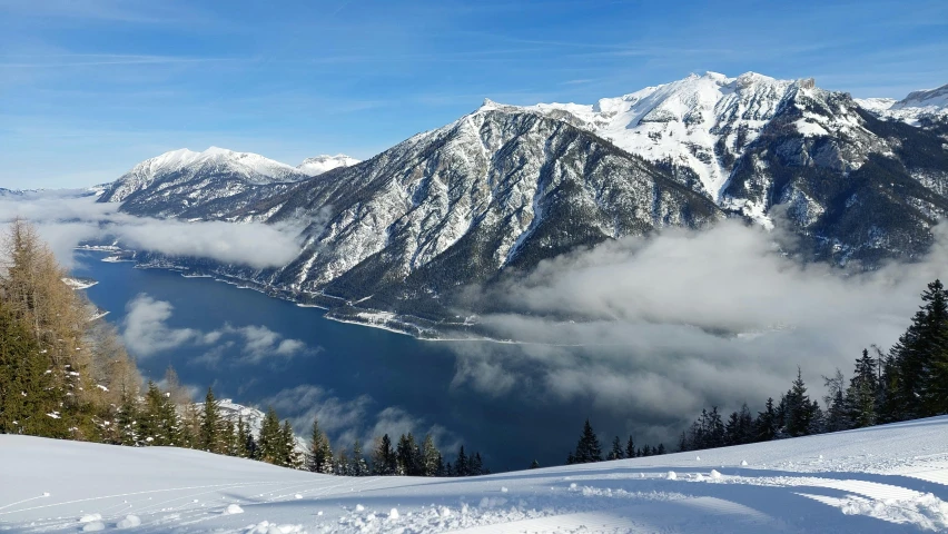 a person stands on top of a mountain on a snowy slope