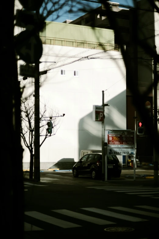 a view of a large building across a street with cars passing by