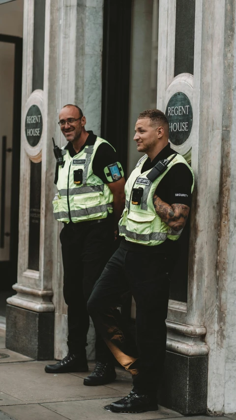 two police officers leaning against the wall of a building