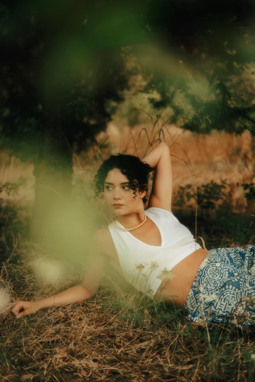 the girl is sitting on the grass posing for a picture