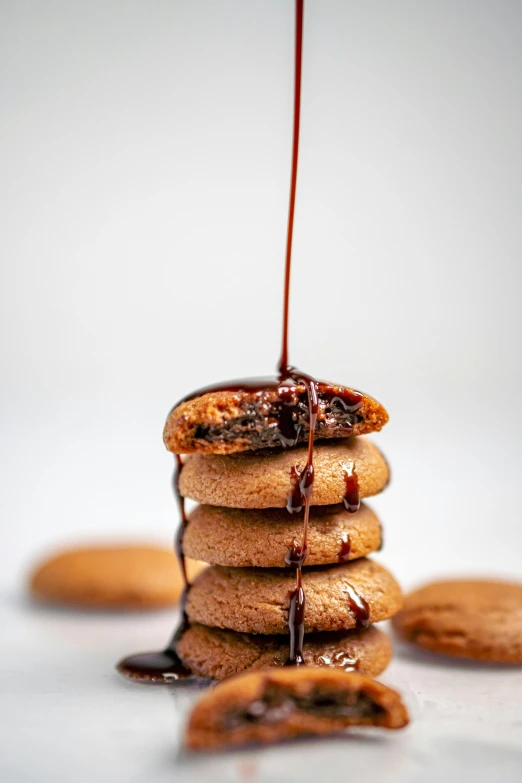 a stack of cookies covered in syrup and drizzled with chocolate