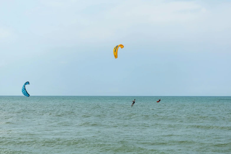 a couple of parasailers in the middle of an ocean