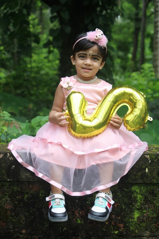 a small girl with a number shaped balloon