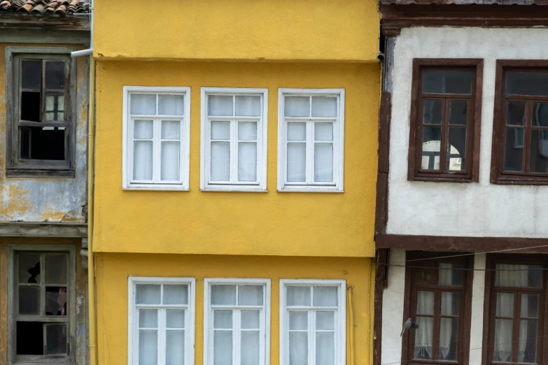 yellow building with windows, painted red and white