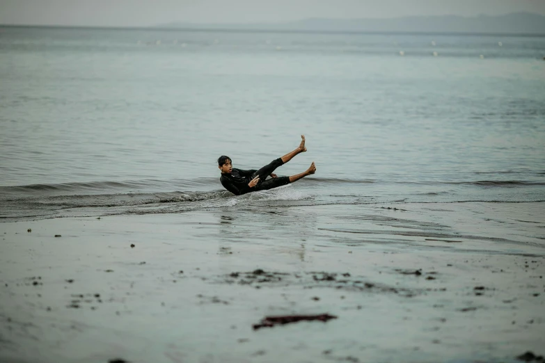 a man laying in the ocean on his surf board