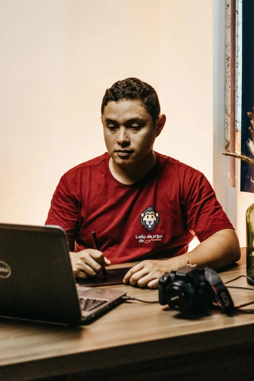 a person sitting at a table with a laptop and two bottles of wine